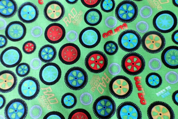 Green fabric with wheels - Northcott Fabric – Rad Riders #3135 by Terry Perry